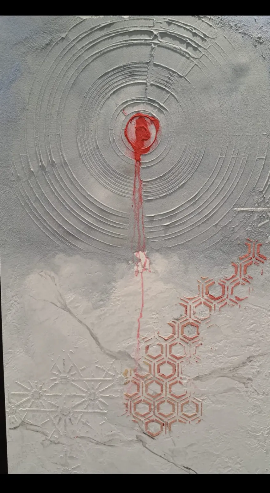 Textured plaster panel with red bullseye and stencilled pattern
